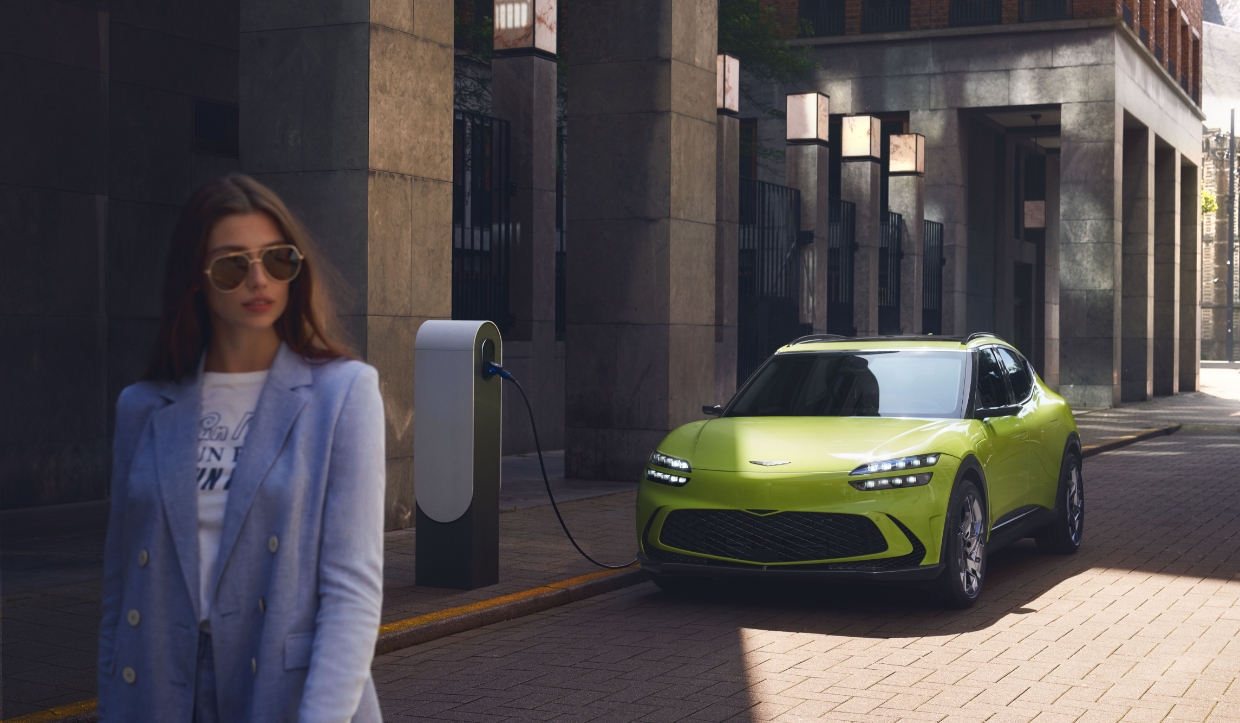 유럽의 어느 건물 앞 배터리 충전기에 주차되어 있는 GV60의 모습