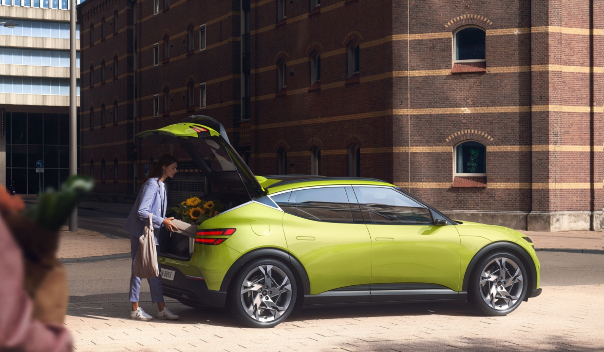 한 여자가 GV60의 트렁크를 열고 짐을 싣고 있는 모습