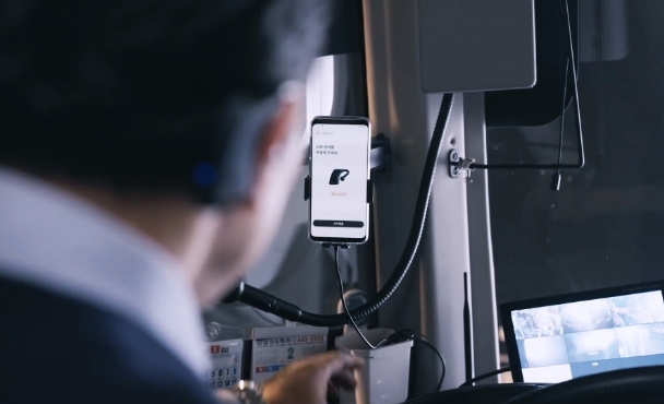 A bus driver using M.Brain checks the smartphone image