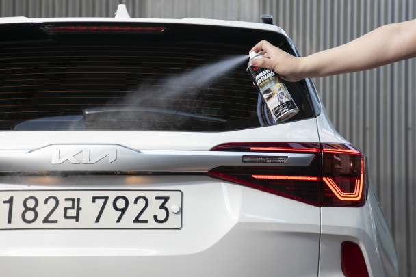 Spraying tar remover on vehicle