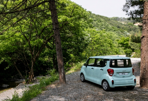 숲을 배경으로 서 있는 레이 1인승 밴의 뒷모습