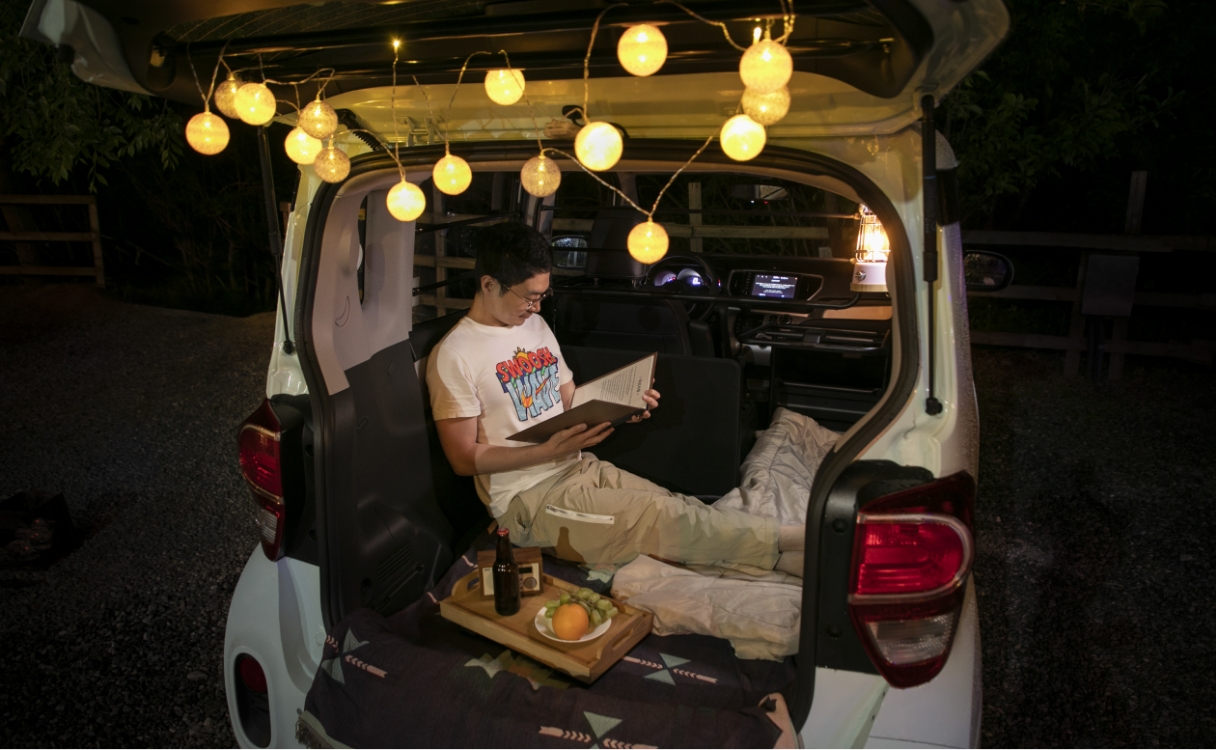 An adult reading a book in a single-seater Ray's cabin