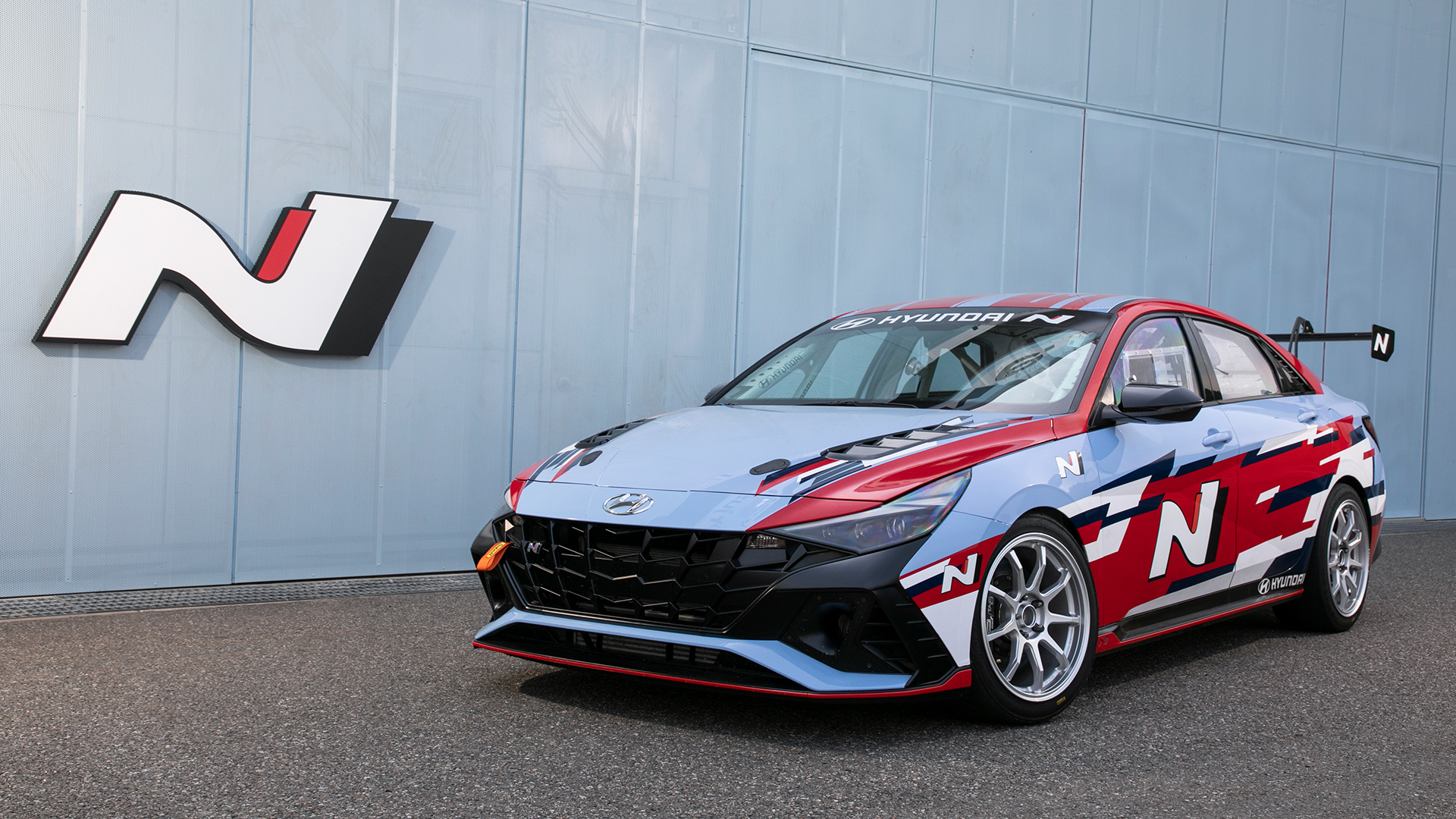 Avante N racing car standing in the background with the N branded building
