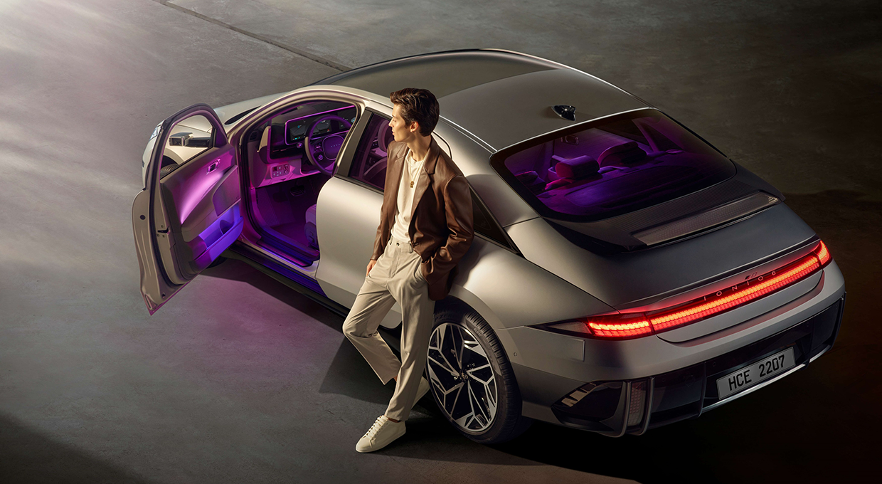 운전석 문이 열린 아이오닉 6 후측면부와 차량에 기댄 남자의 모습