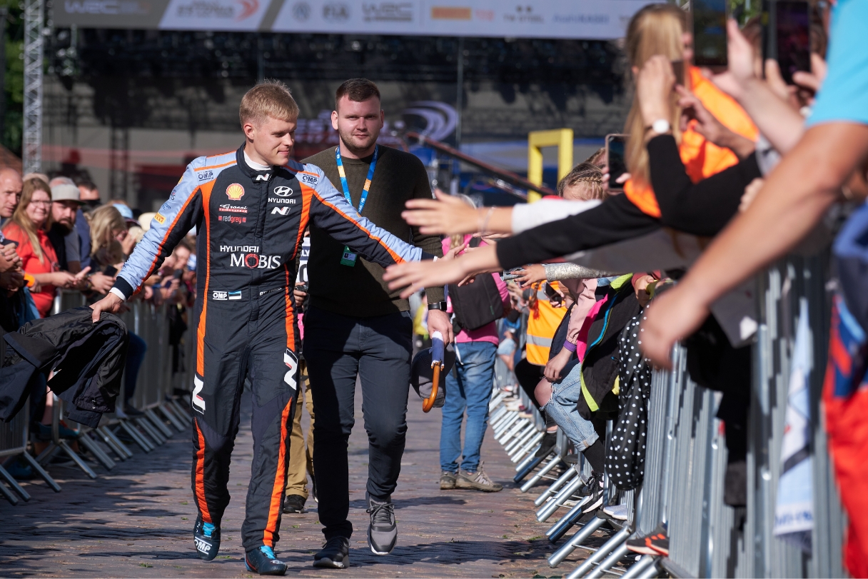 오트 타낙이 랠리 팬들과 손을 맞대는 팬서비스를 하고 있다