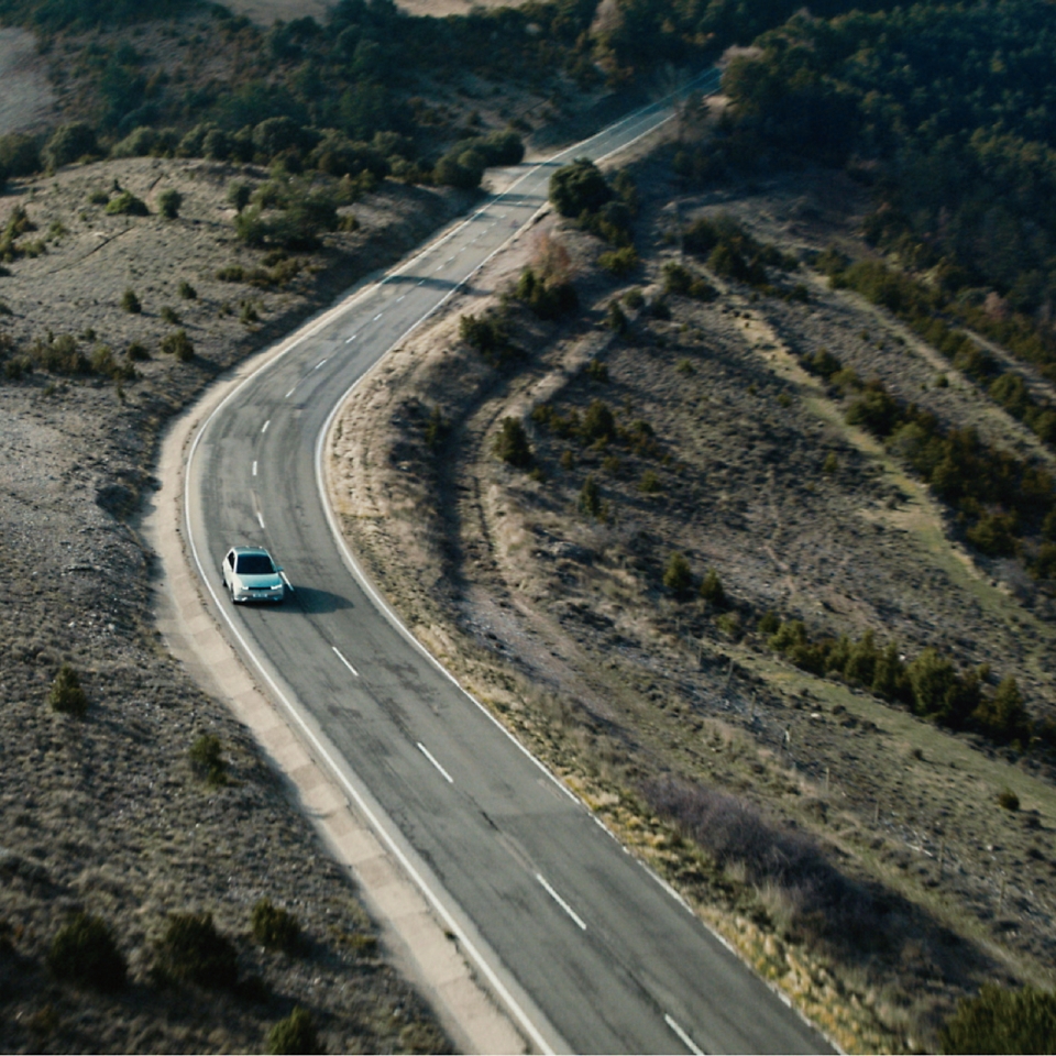 들판 위의 도로를 달리는 자동차 풍경