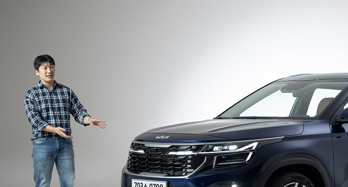 외장 디자이너가 더 뉴 셀토스의 그릴과 헤드램프를 설명하고 있는 모습