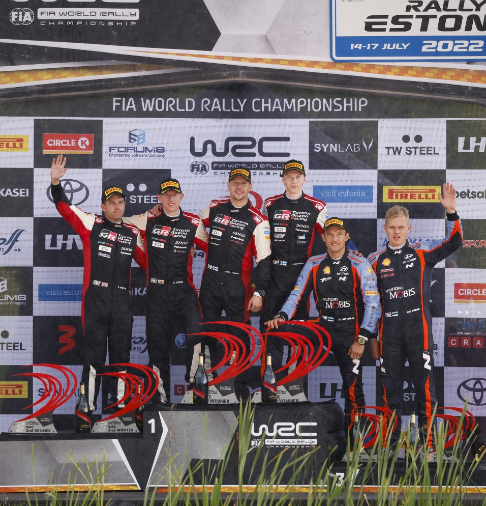 Ott Tanak and Martin Järveoja and others pose on the podium
