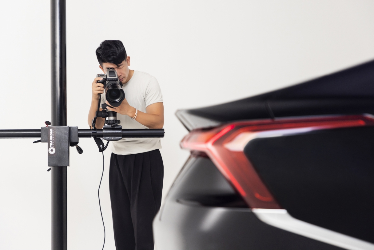 Photographer Seongpil Min is taking pictures of a car with his camera equipment