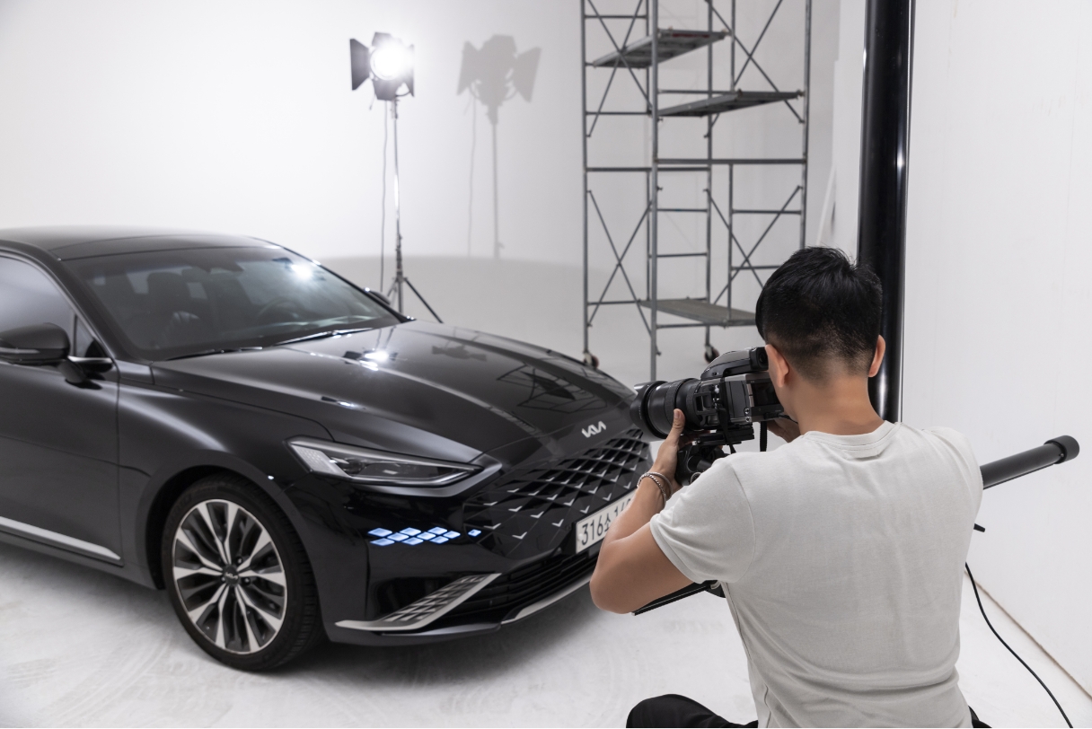 Photographer Seongpil Min is taking pictures of a Kia K8 in the studio