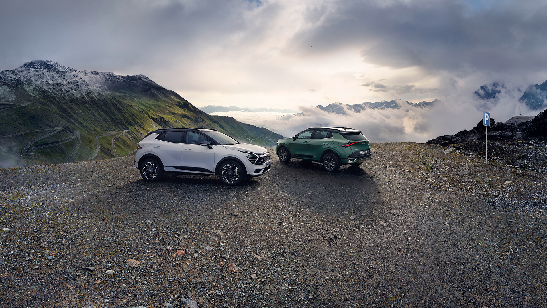 웅장한 자연을 배경으로 서 있는 기아 스포티지의 모습