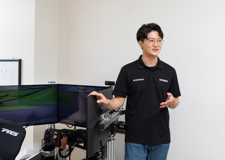 Young-chan Kim standing next to the simulator
