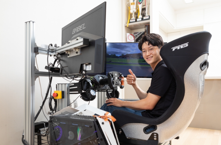 Young-chan Kim posing while sitting inside the simulator