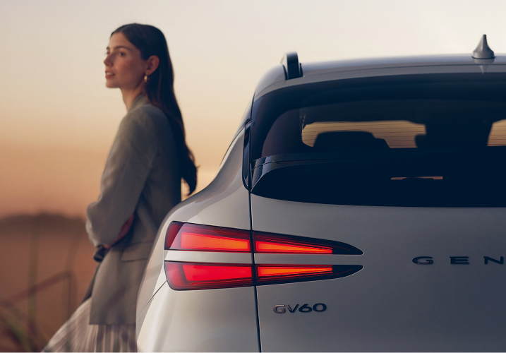 GV60 측면에 여성 모델이 기댄 모습