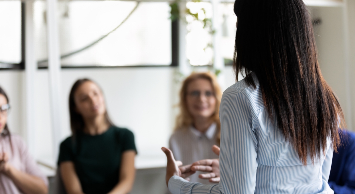 사람들 앞에서 이야기하는 여자의 뒷모습