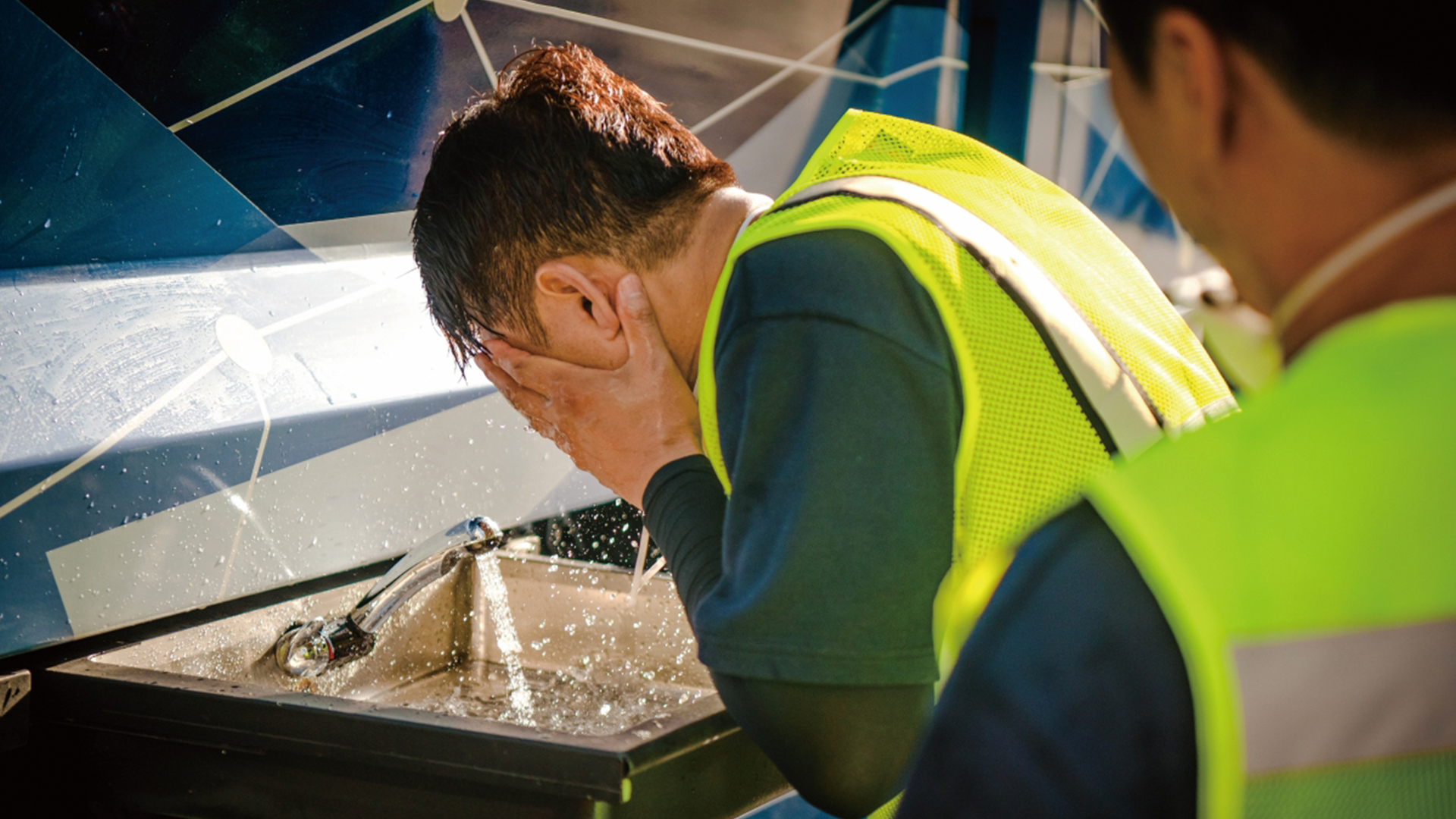 A sanitation worker washing face in a hydrogen cleaning truck