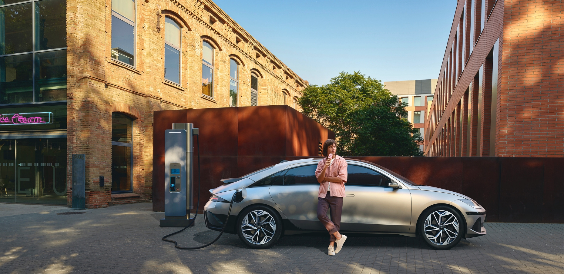 A man is posing leaning on the IONIQ 6