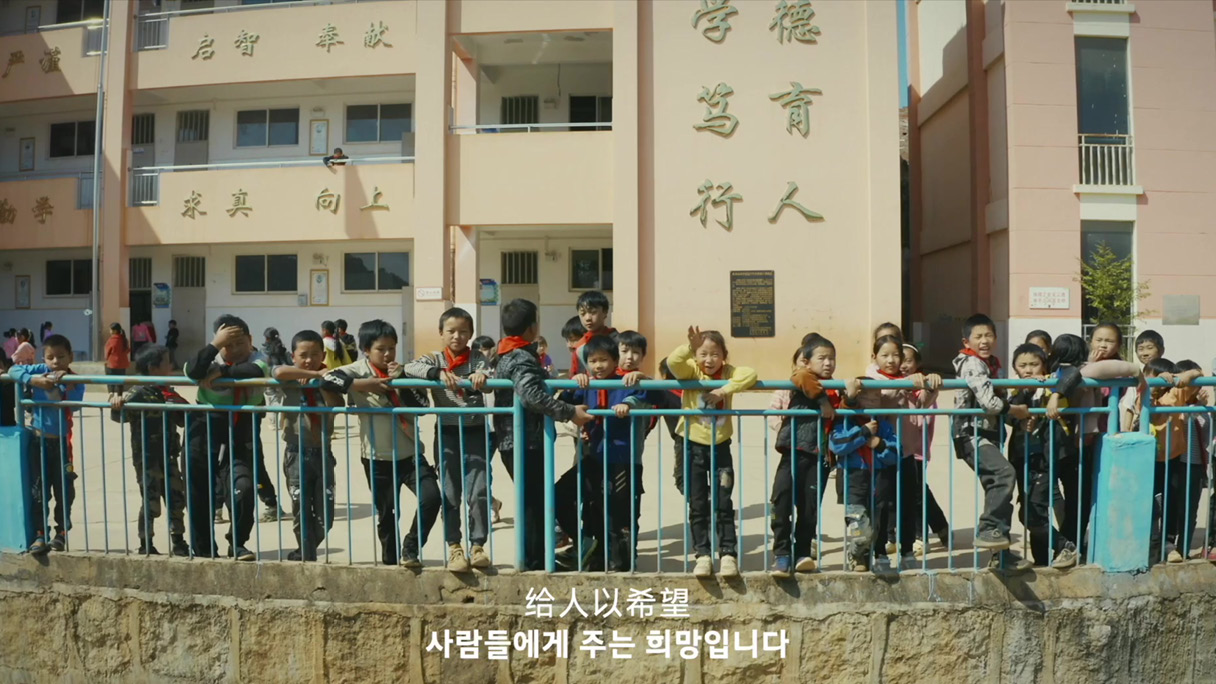 희망 초등학교 학생들이 담장에 서 있는 모습 이미지