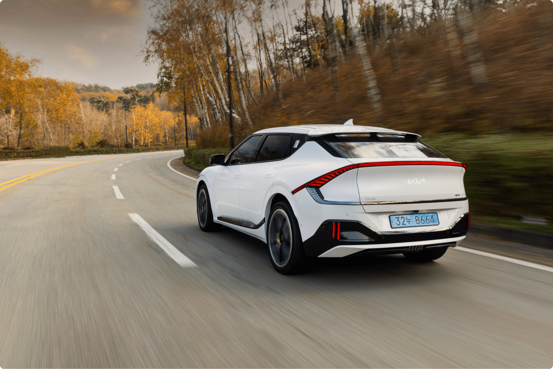 Rear view image of Kia EV6 GT running on a winding course