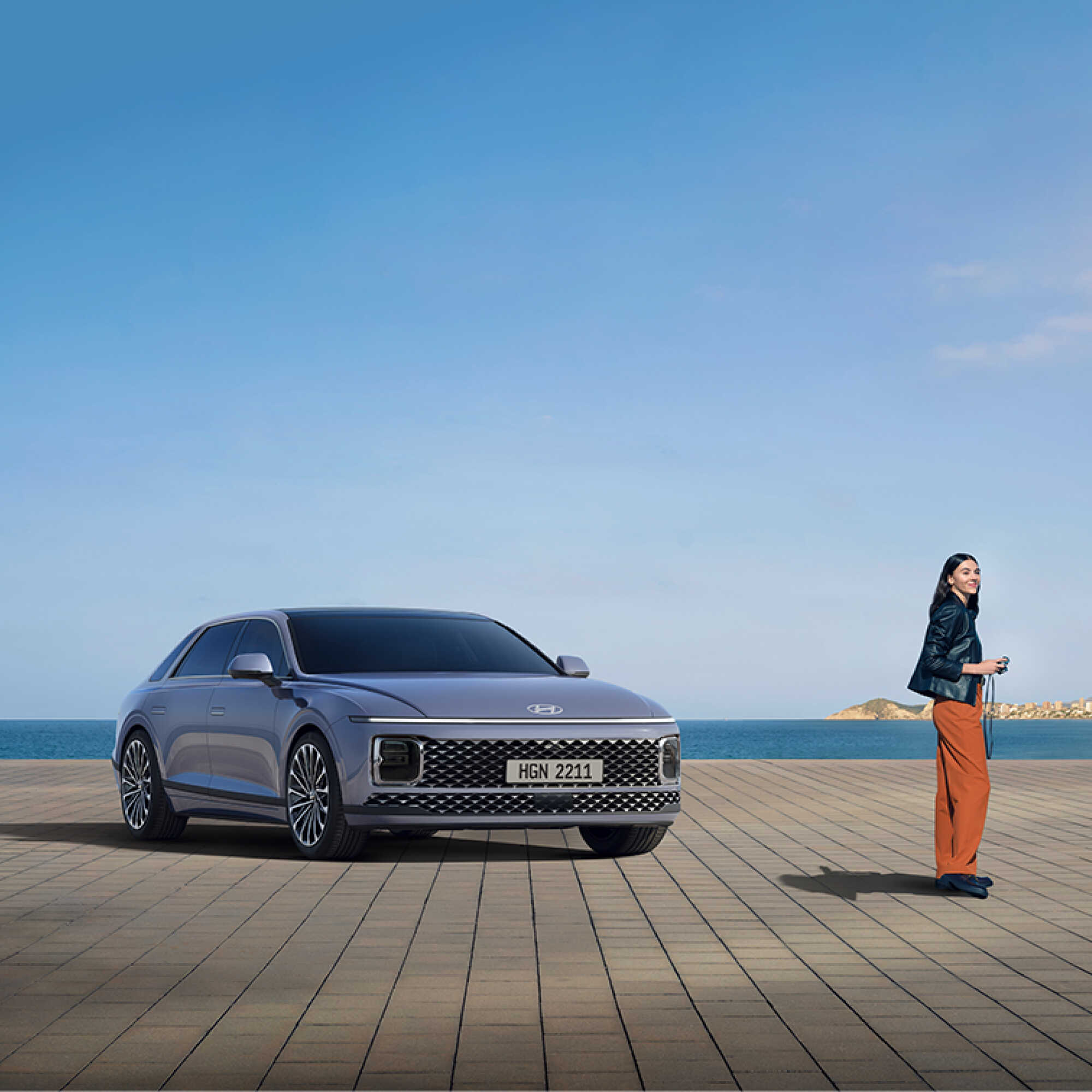 디 올 뉴 그랜저 앞에 한 여성이 서 있는 모습