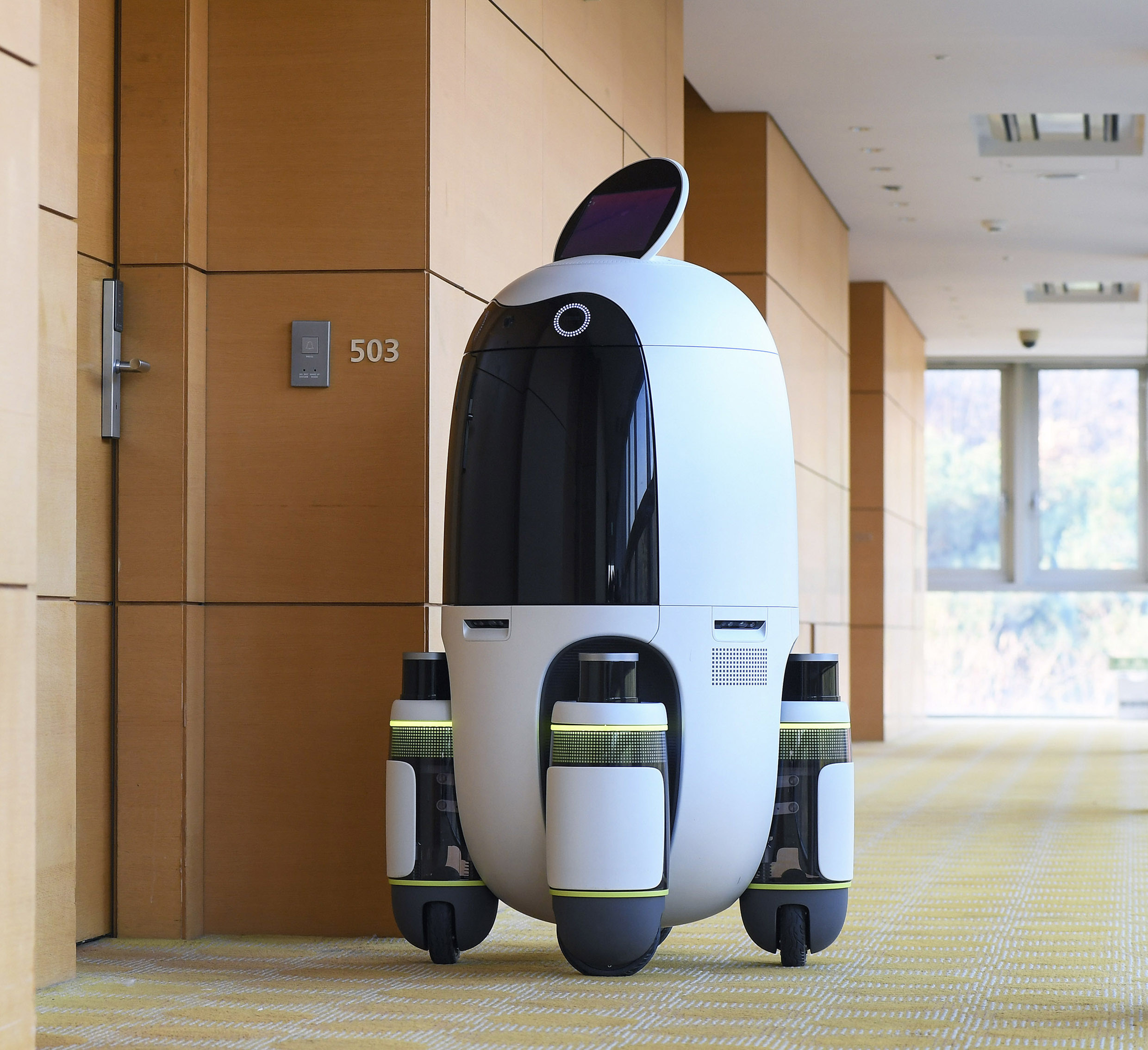 A delivery robot moving through a hotel hallway