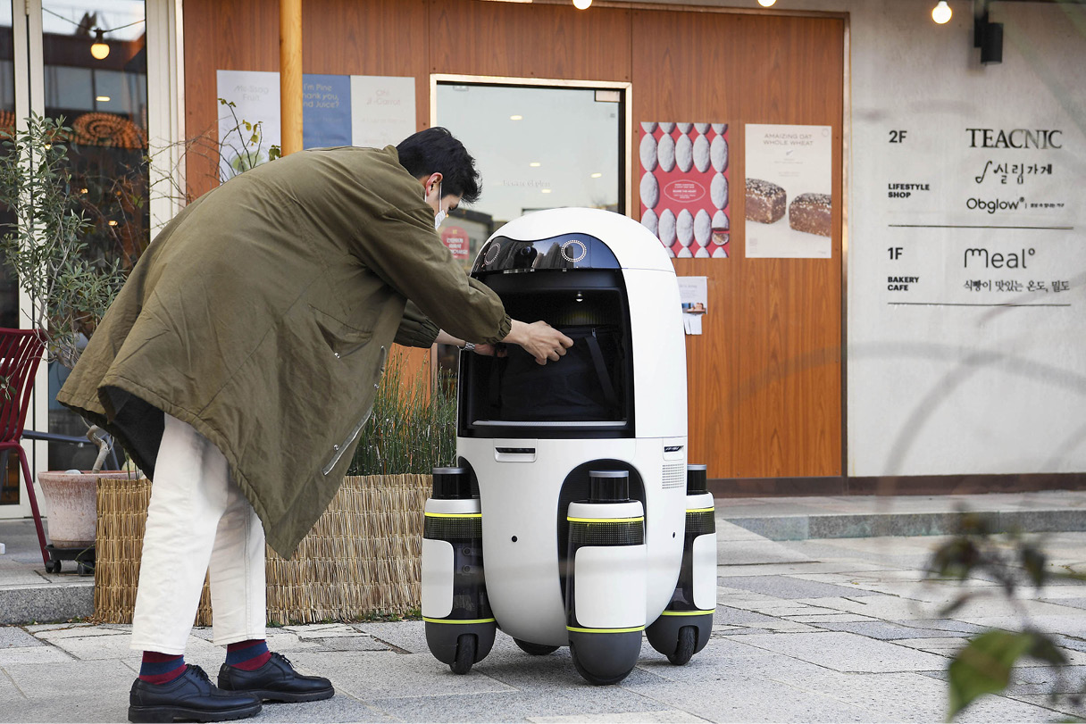 person taking items out of a delivery robot