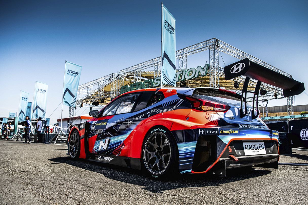 A Veloster racing car parked next to an energy station