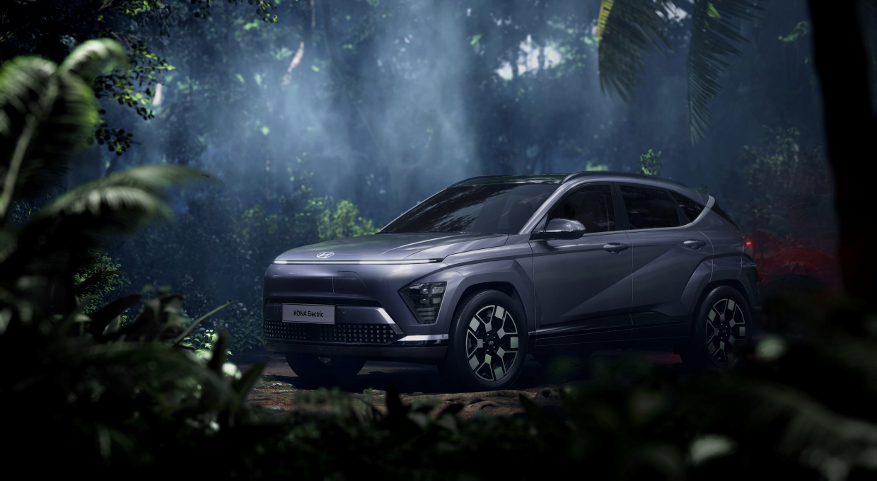 숲 속에 정차하고 있는 디 올 뉴 코나 EV 모델 전측면부