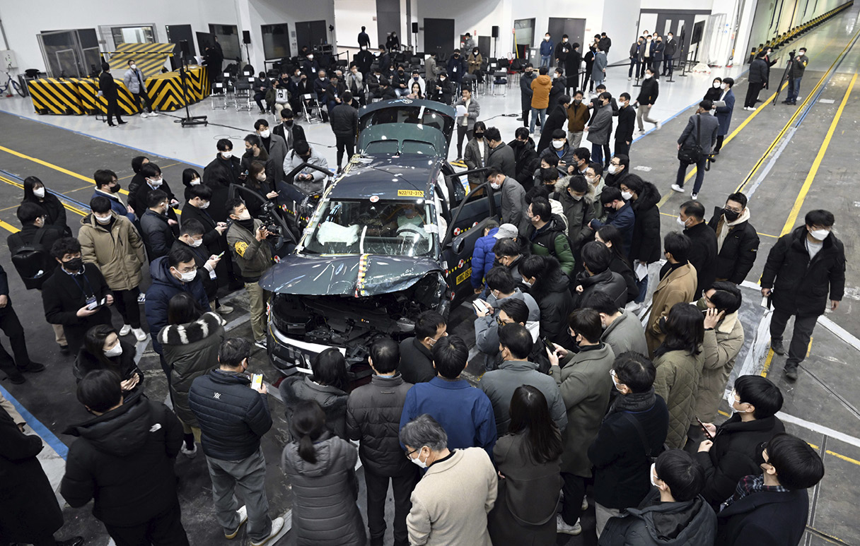 기자단이 파손된 아이오닉 5 주위에 모여 차량을 살펴보고 있다