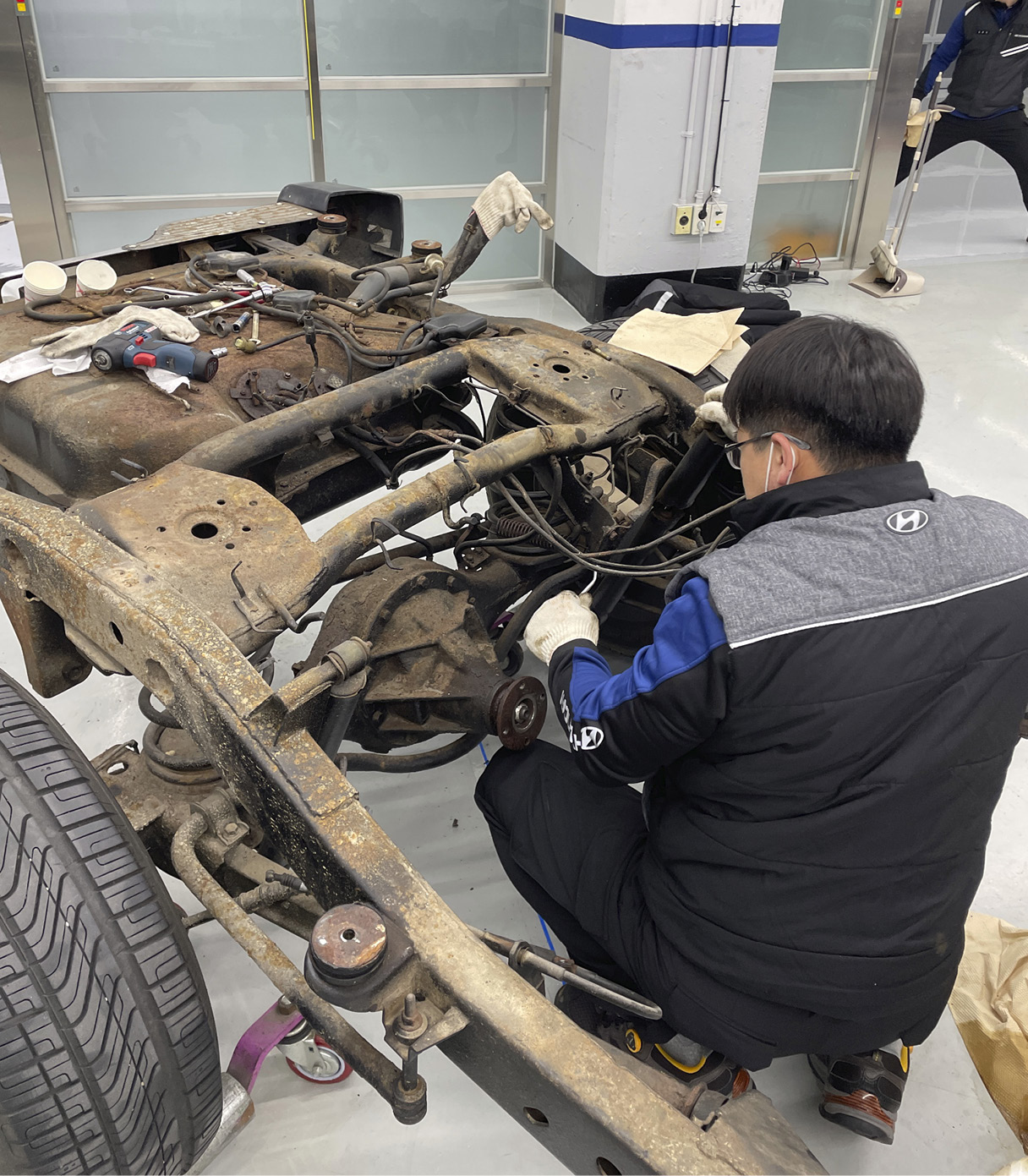 A worker looking at a corroded frame