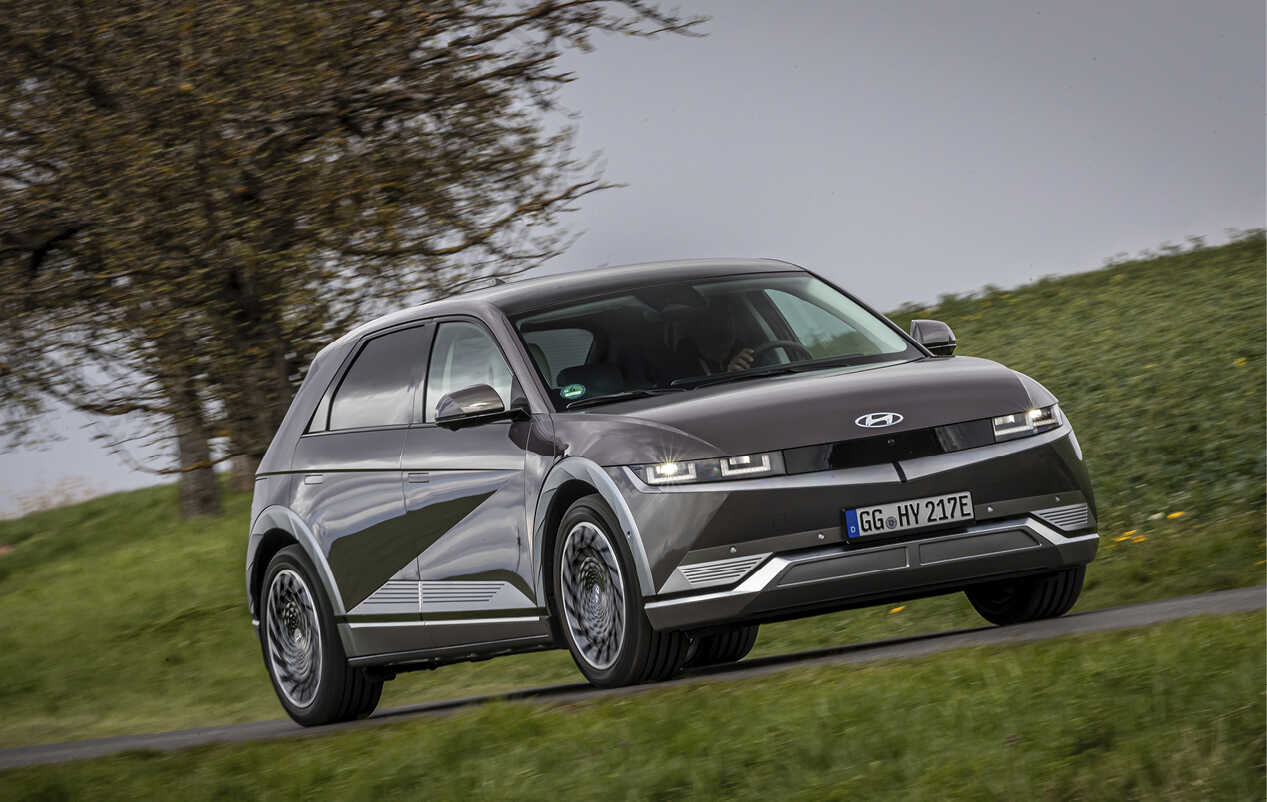 아이오닉 5가 한적한 유럽 교외 도로를 주행하는 전측면 모습