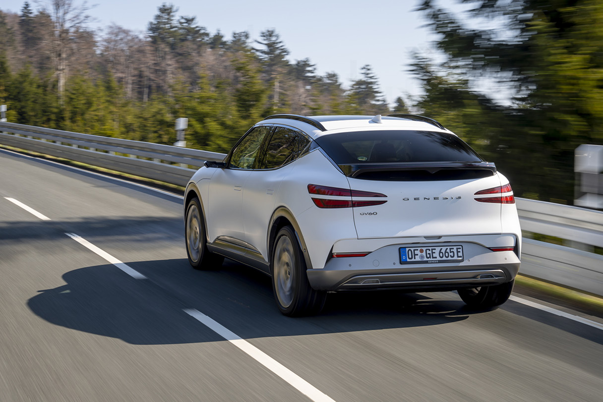 GV60이 유럽의 숲 속 도로를 주행하는 모습