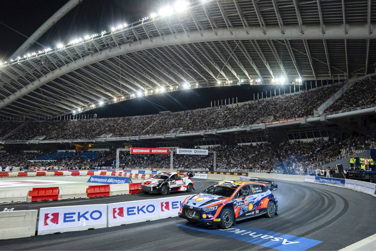 A racing car running on a special stage receiving cheers from countless spectators