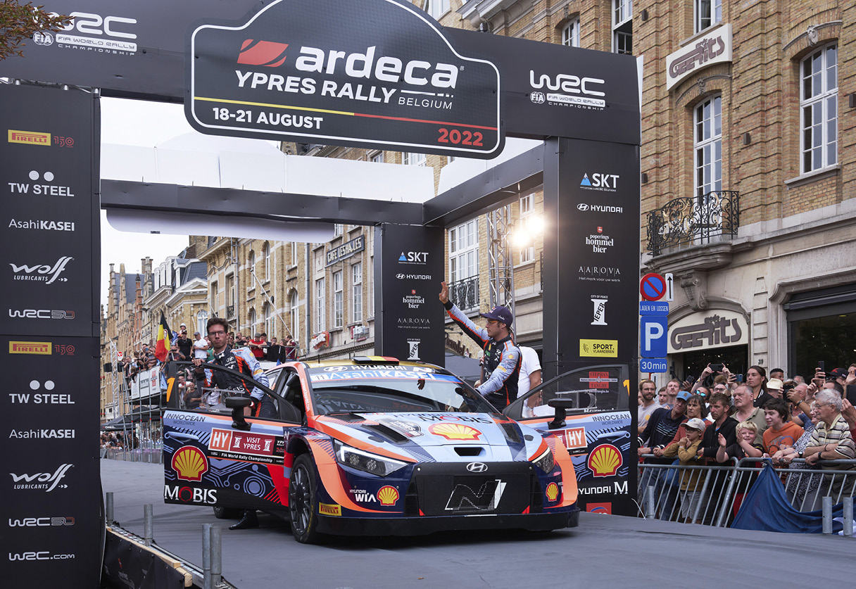 Hyundai WRC team drivers standing at the starting line and waving to the crowd