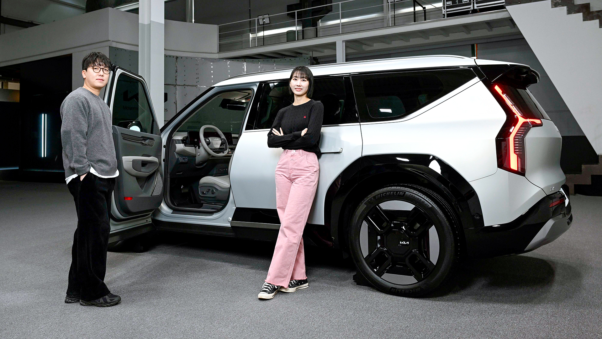 남자 연구원과 여자 연구원이 EV9 측면에 나란히 서 있는 모습