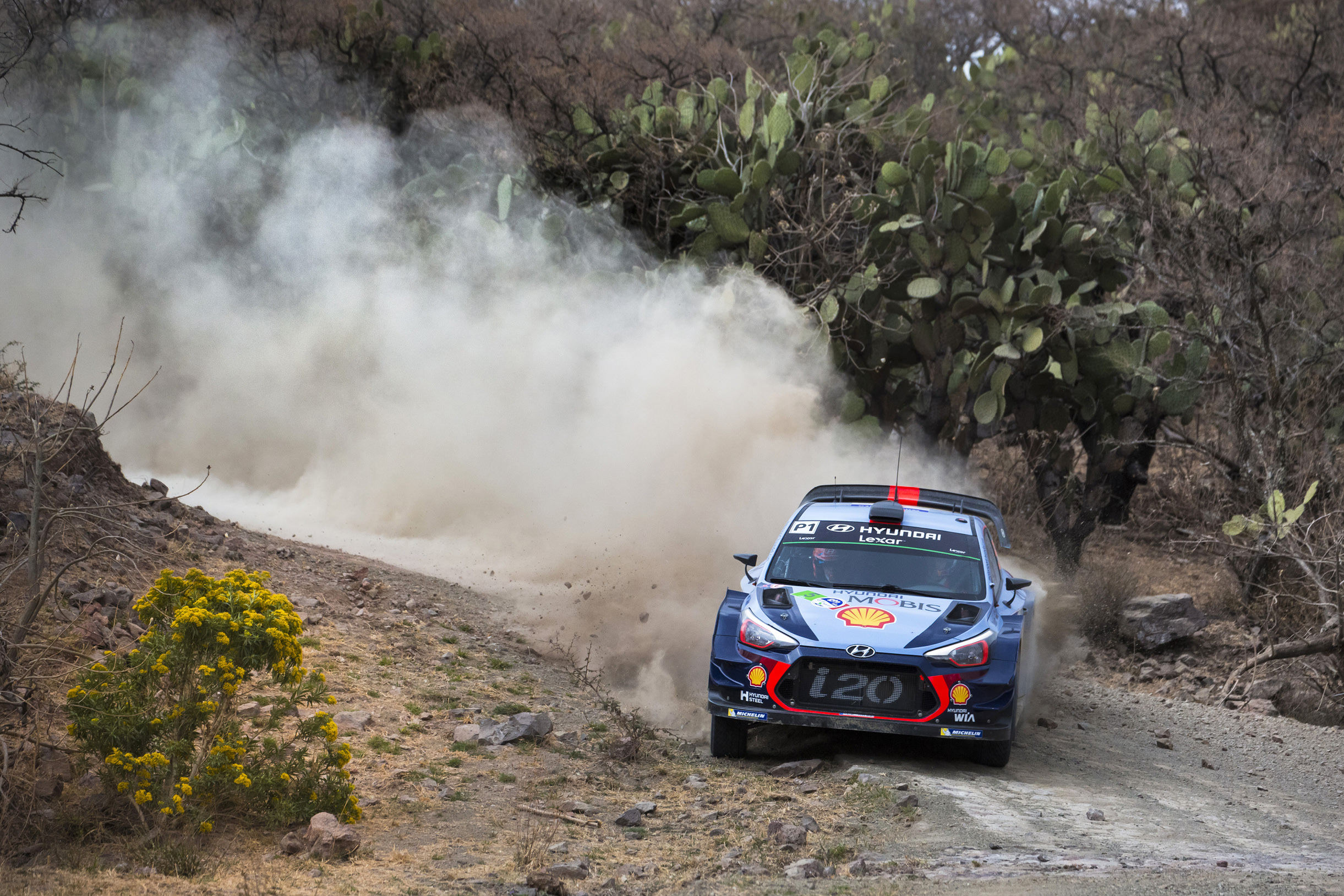 Hyundai i20 rally car running through dust