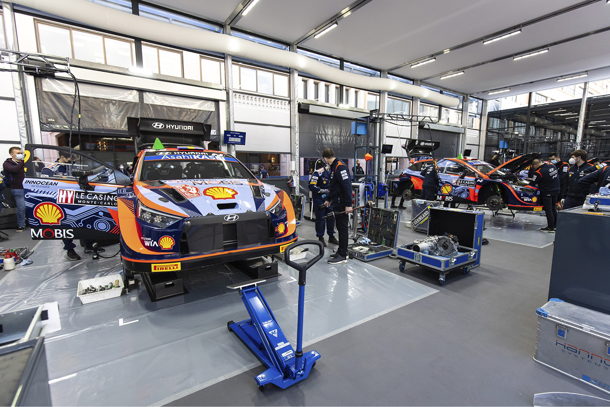 Alt text: Rally car being repaired at Hyundai Motorsport Team's pit stop