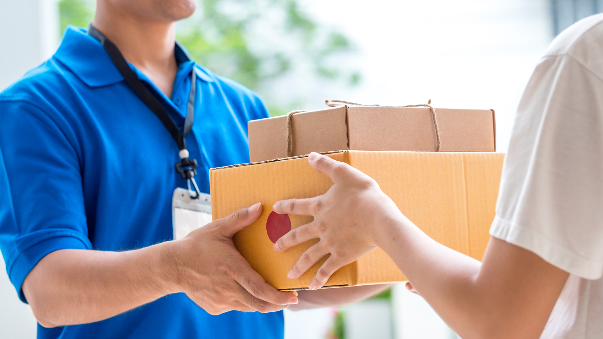 한 사람이 택배 상자를 건네 받고 있다