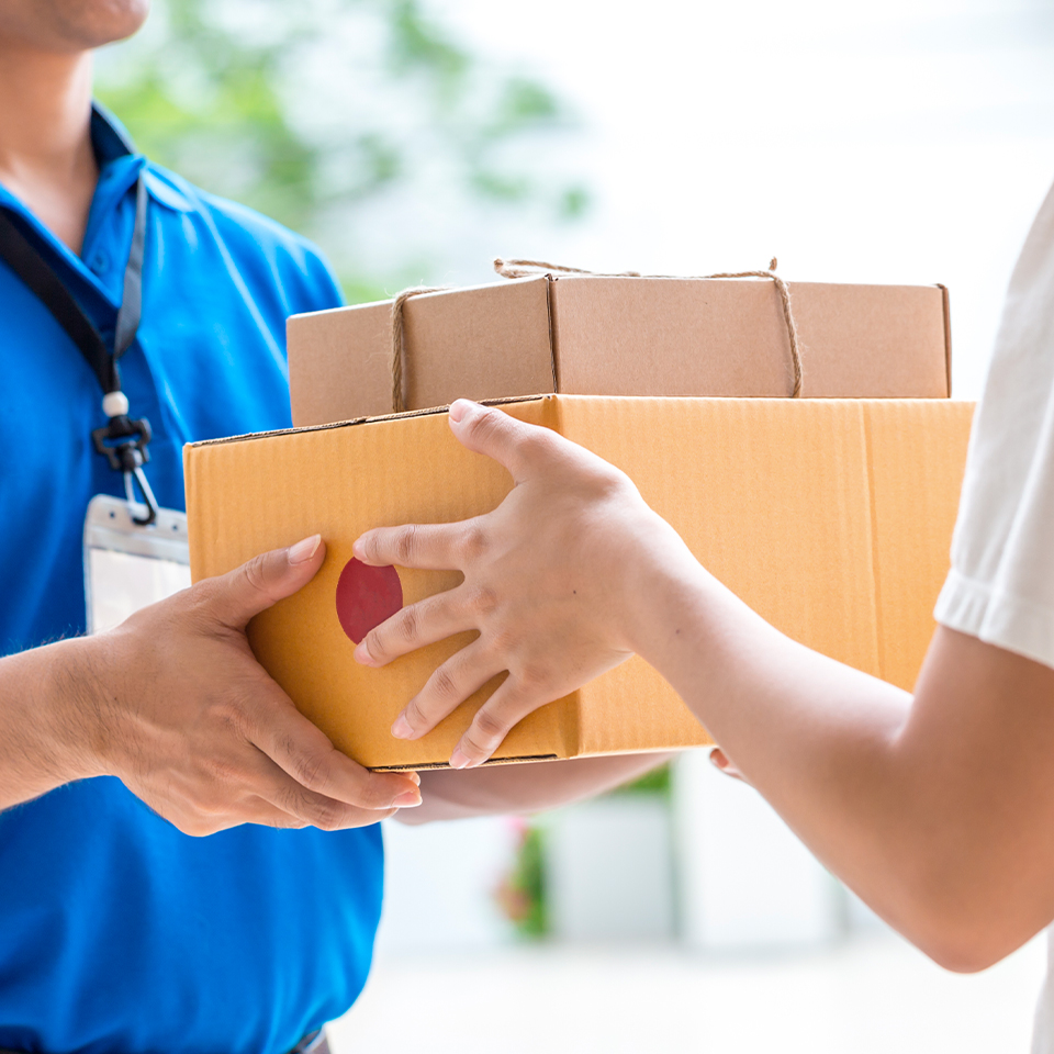 한 사람이 택배 상자를 건네 받고 있다