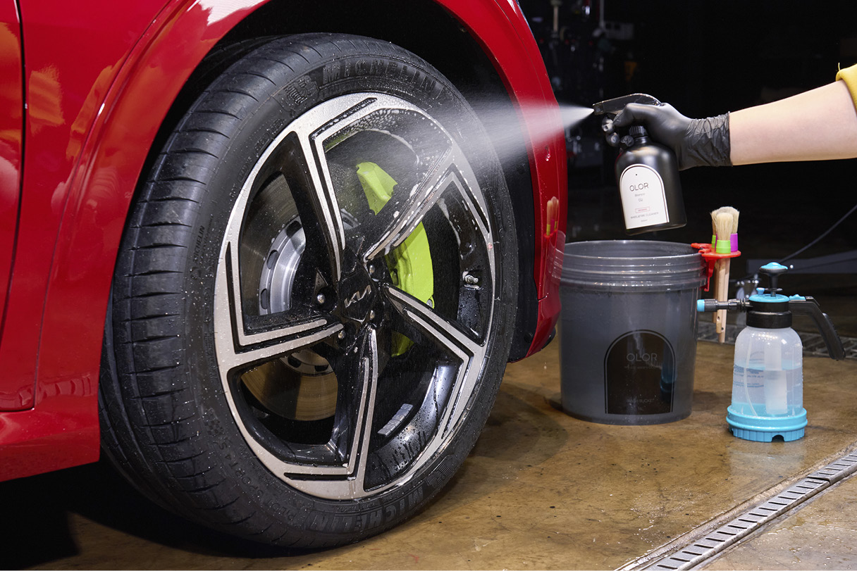 Spraying wheel cleaner on a wheel