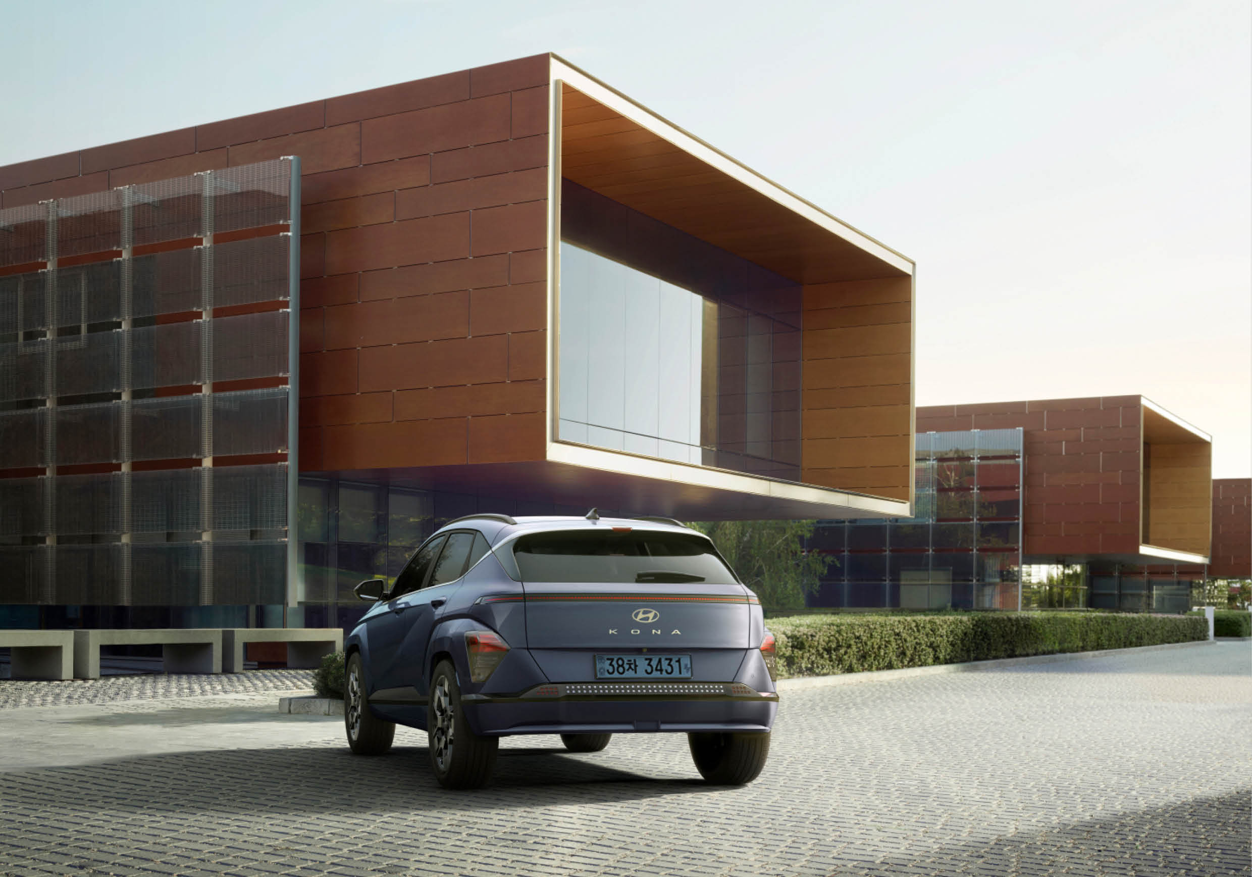 건물 앞에 서 있는 2세대 코나 일렉트릭