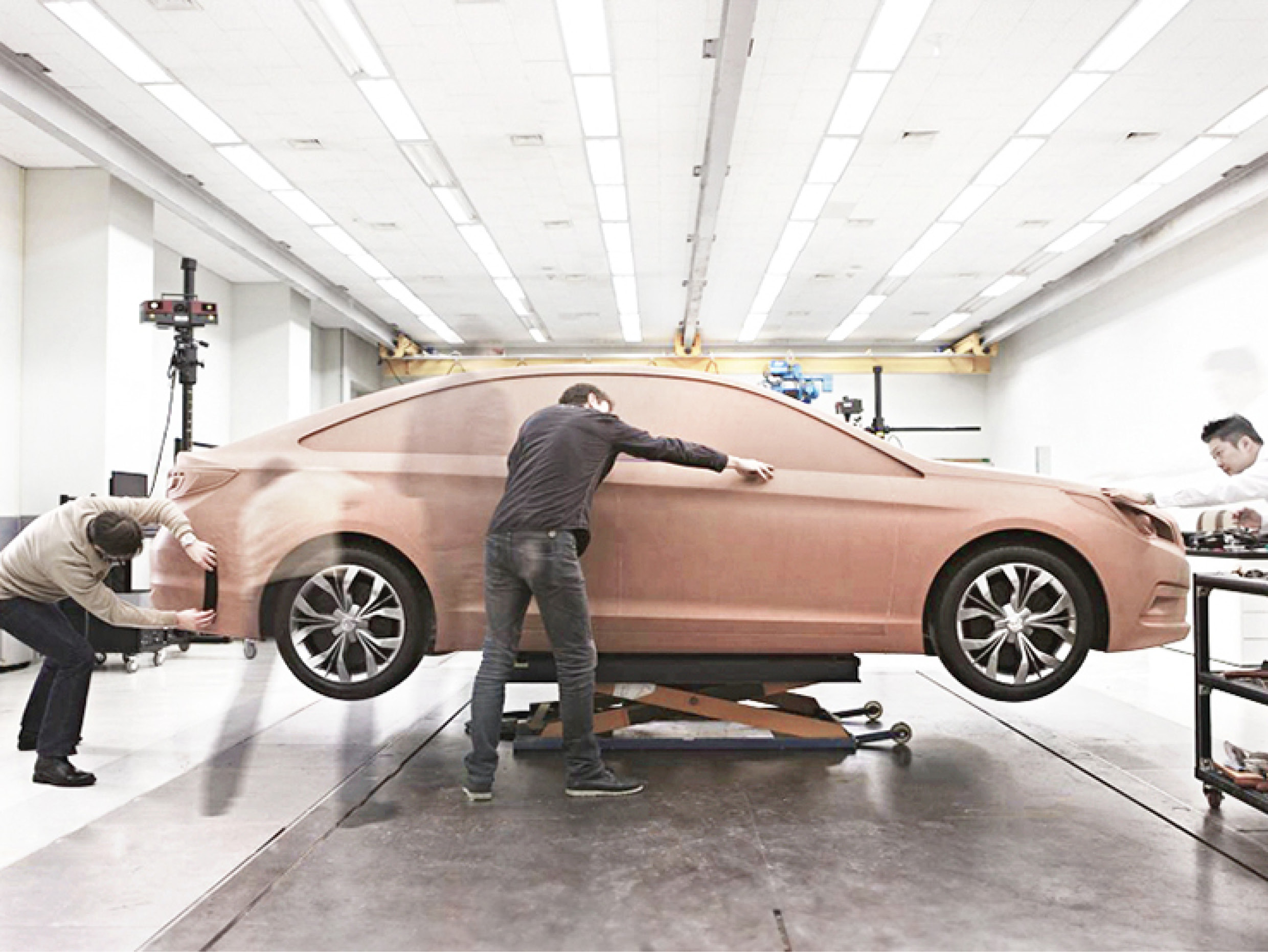 automobile designers trimming on clay mock-up