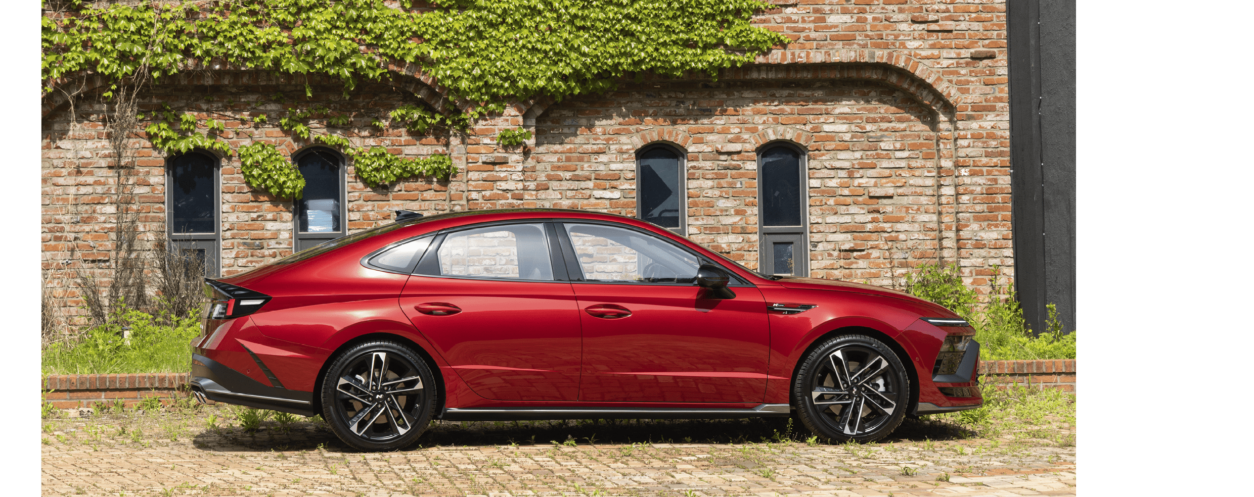 쏘나타 디 엣지 N 라인 2.5 터보가 건물 앞에 주차된 측면 모습