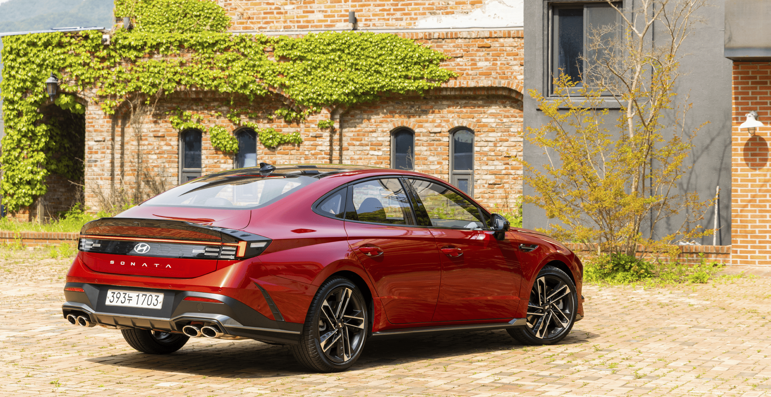 쏘나타 디 엣지 N 라인 2.5 터보가 건물 앞에 주차된 후측면 모습