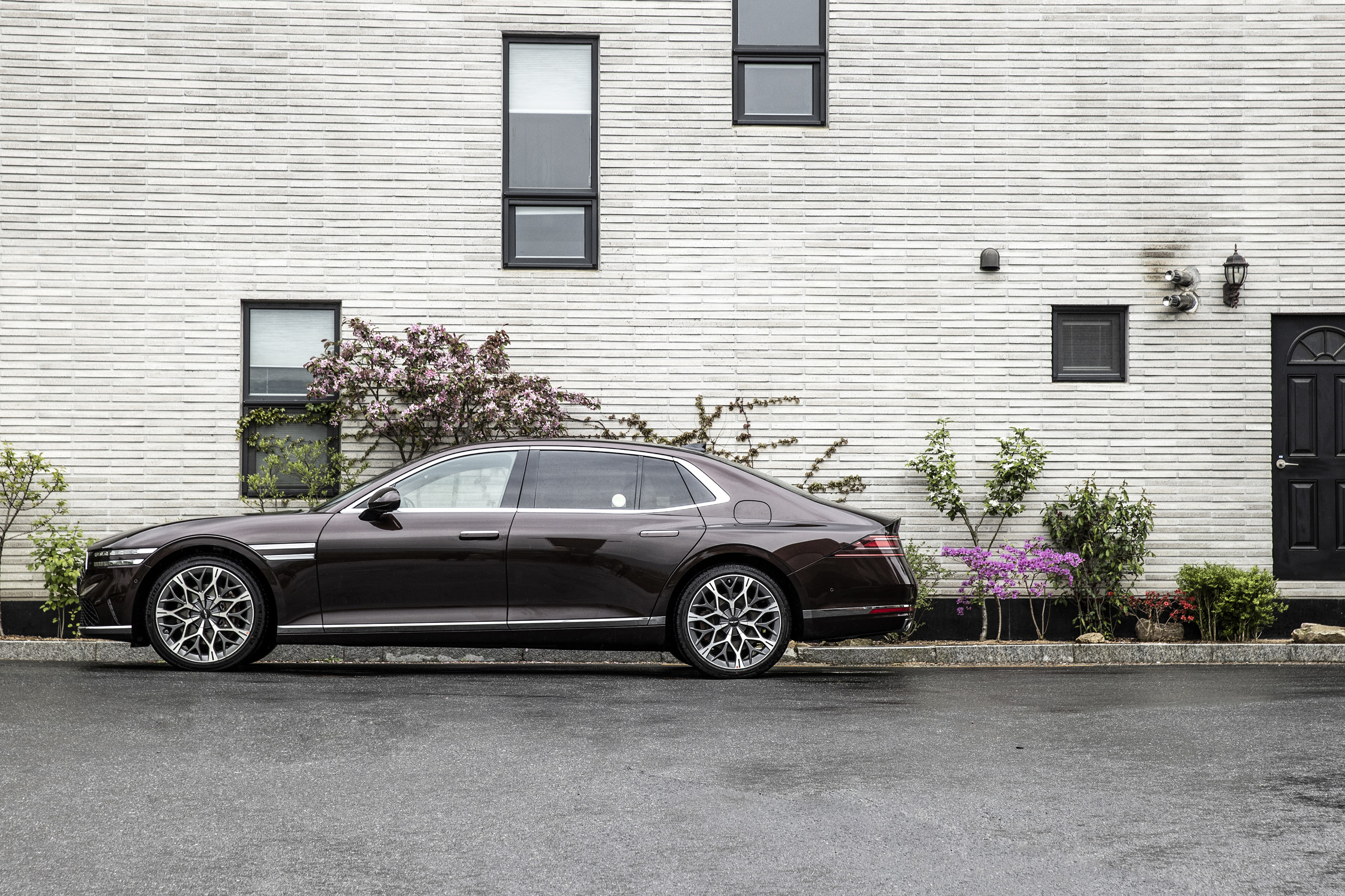 여러 개의 창문이 있는 건물에 서 있는 G90의 측면