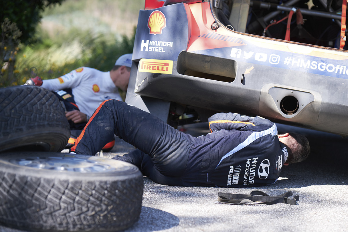 Hyundai Motorsport racers repairing a race car at Rally Portugal
