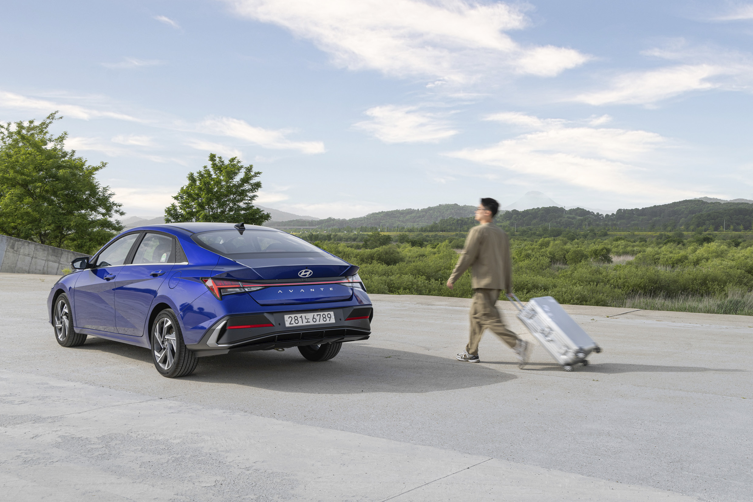 아반떼 주변으로 캐리어를 끈 남성이 지나는 모습