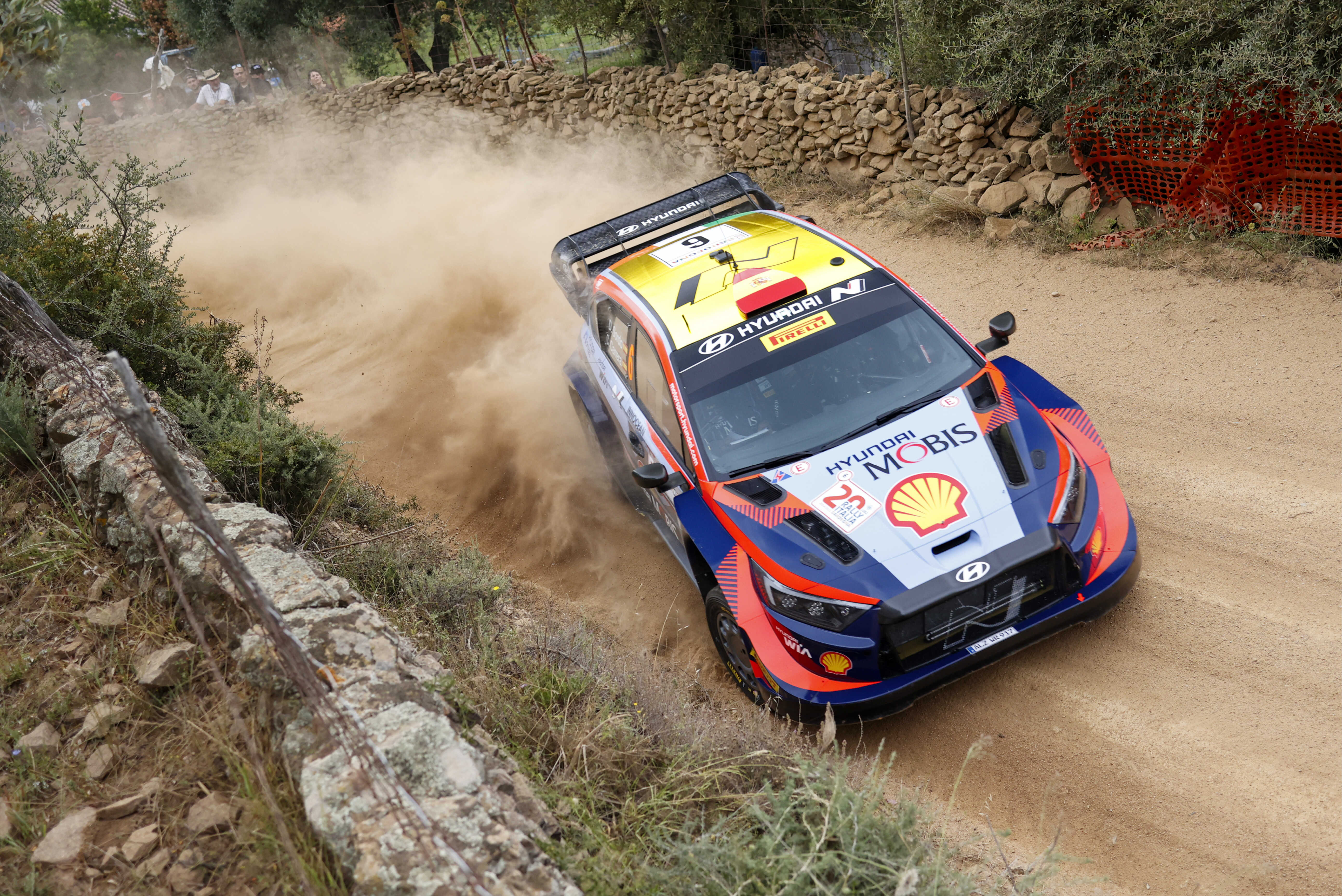 A Hyundai rally car is speeding down a dirt road