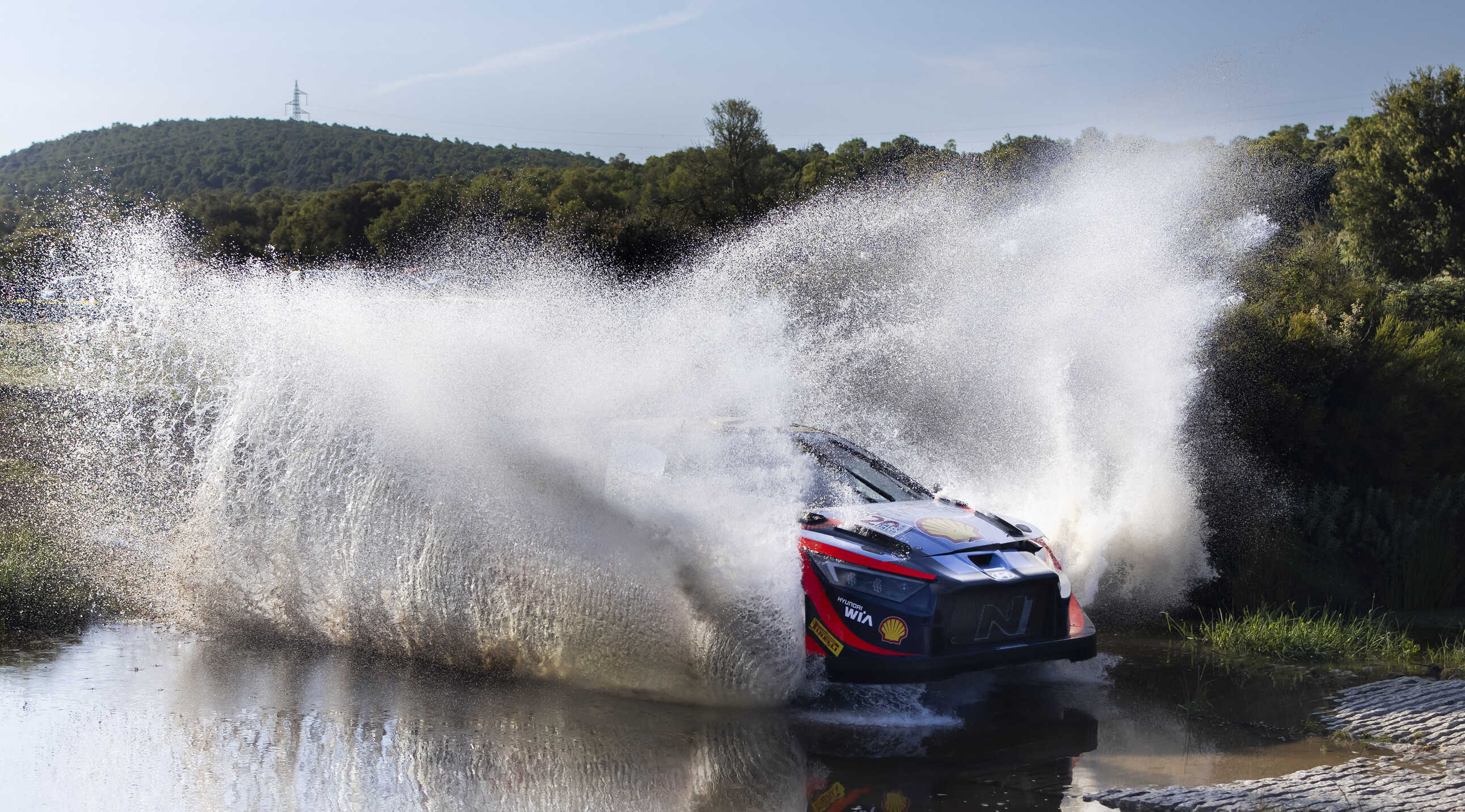 Hyundai's rally car vigorously crossing a stream