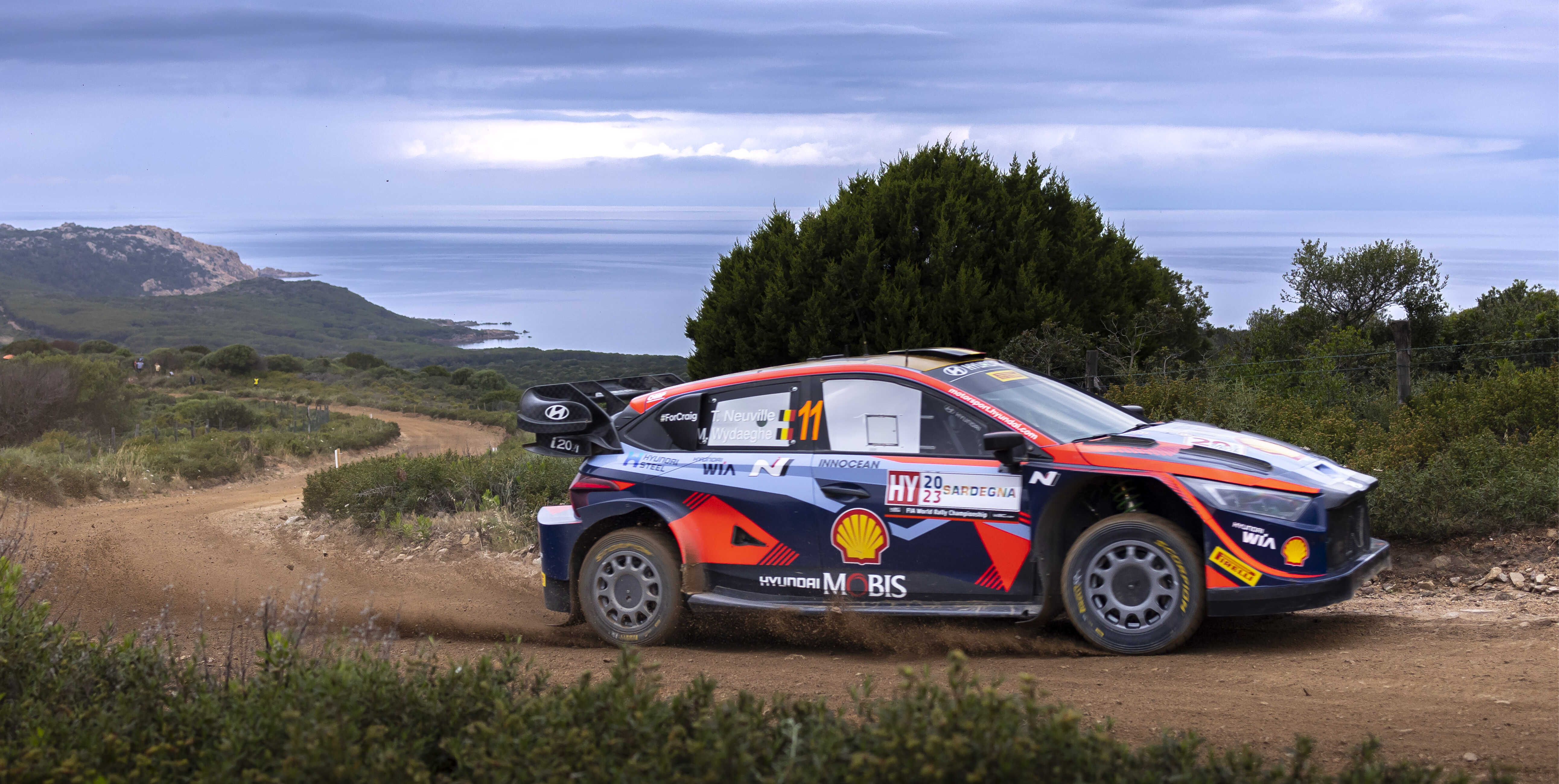 A Hyundai rally car is speeding through a winding mountain road